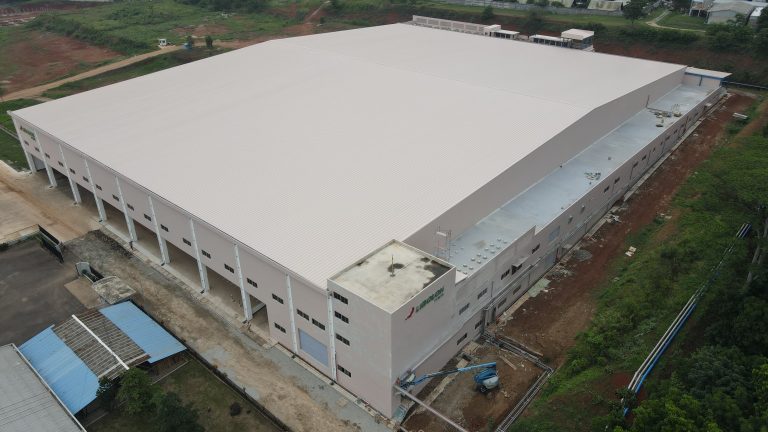 Proyek konstruksi gudang industri skala besar dengan struktur baja dan atap metal.