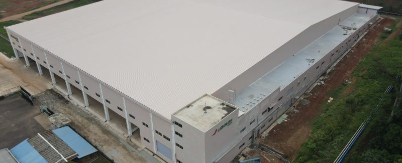 Proyek konstruksi gudang industri skala besar dengan struktur baja dan atap metal.